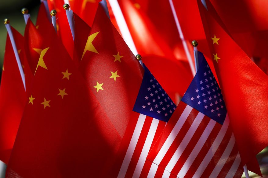 The flags of the U.S. and Chinese are displayed together on top of a trishaw in Beijing on Sept. 16, 2018. American cybersecurity firm says a Chinese hacking group that is likely state-sponsored and has been linked previously to attacks on U.S. state government computers is still “highly active” and is focusing on a broad range of targets that may be of strategic interest to China’s government and security services.(AP Photo/Andy Wong, File)