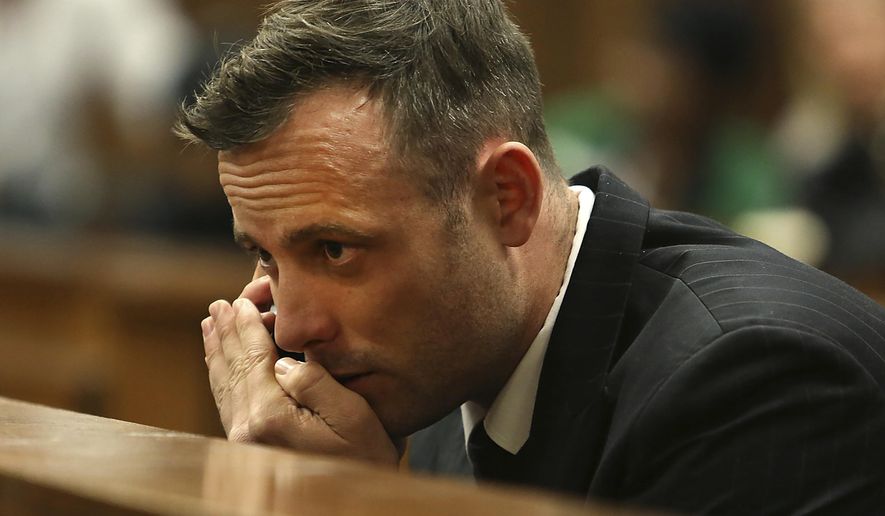 Oscar Pistorius speaks on a mobile phone in the High Court in Pretoria, South Africa, June 15, 2016, during his sentencing hearing for murdering girlfriend Reeva Steenkamp. Pistorius has applied for parole and is expected to attend a hearing on Friday, March 31, 2023, that will decide if the former Olympic runner is released from prison 10 years after killing girlfriend Reeva Steenkamp. (Alon Skuy/Pool Photo via AP, File)