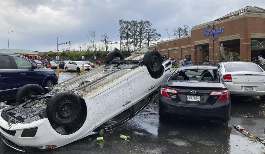 A car is upturned in a Kroger parking lot after a severe storm swept through Little Rock, Ark., Friday, March 31, 2023. (AP Photo/Andrew DeMillo)