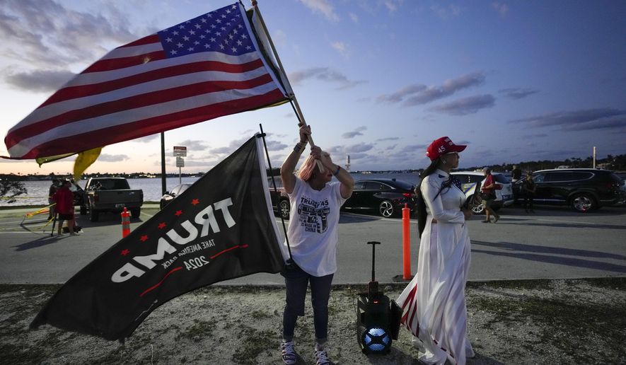 Trang Le of Orlando, right, and Maria Korynsel of North Palm Beach show their support for former President Donald Trump after the news broke that Trump has been indicted by a Manhattan grand jury, Thursday, March 30, 2023, near Trump&#x27;s Mar-a-Lago estate in Palm Beach, Fla. (AP Photo/Rebecca Blackwell)