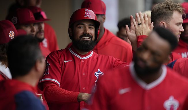 Los Angeles Angels&#x27; Anthony Rendon celebrates in the dugout after scoring off of a home run hit by Jo Adell during the first inning of a spring training baseball game against the Arizona Diamondbacks in Scottsdale, Ariz., Tuesday, March 21, 2023. (AP Photo/Ashley Landis)