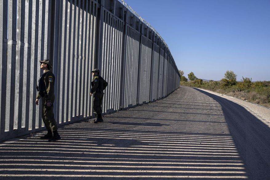 Police border guards patrol along a border wall near the town of Feres, along the Evros River which forms the frontier between Greece and Turkey, on Sunday, Oct. 30, 2022. Greece's prime minister promised to extend a wall across all of the country's land border with Turkey during a campaign stop on Friday, March 31, 2023, ahead of a general election. (AP Photo/Petros Giannakouris, File)