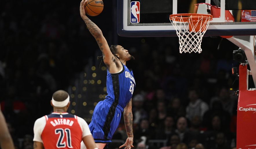 Orlando Magic guard Markelle Fultz (20) goes to the basket as Washington Wizards center Daniel Gafford (21) watches during the first half of an NBA basketball game Friday, March 31, 2023, in Washington. (AP Photo/Nick Wass)