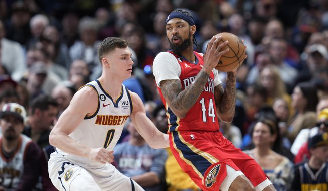 New Orleans Pelicans forward Brandon Ingram, right, looks to pass the ball as Denver Nuggets guard Christian Braun defends during the first half of an NBA basketball game Thursday, March 30, 2023, in Denver. (AP Photo/David Zalubowski)
