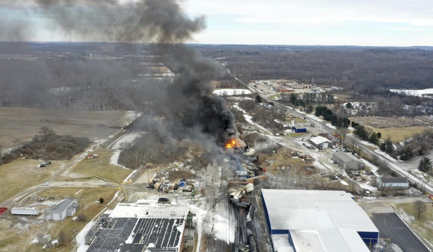 This photo taken with a drone shows portions of a Norfolk and Southern freight train that derailed Friday night in East Palestine, Ohio are still on fire at mid-day Saturday, Feb. 4, 2023. The federal government filed a lawsuit Thursday, March 30, against railroad Norfolk Southern over environmental damage caused by a February derailment on the Ohio-Pennsylvania border that spilled hazardous chemicals into nearby creeks and rivers. (AP Photo/Gene J. Puskar, File)