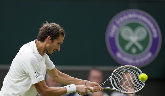 Russia&#x27;s Daniil Medvedev plays a return to Poland&#x27;s Hubert Hurkacz during the men&#x27;s singles fourth round match on day eight of the Wimbledon Tennis Championships in London, Tuesday, July 6, 2021. Russian and Belarusian players will be able to compete at Wimbledon as neutral athletes after the All England Club on Friday, March 31, 2023, reversed its ban from last year. (AP Photo/Kirsty Wigglesworth, File)