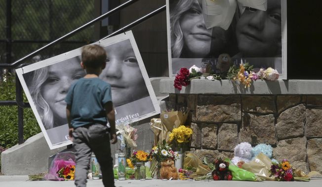 A boy looks at a memorial for Tylee Ryan and Joshua &quot;JJ&quot; Vallow in Rexburg, Idaho, on June 11, 2020. A mother charged with murder in the deaths of her two children is set to stand trial in Idaho. The proceedings against Lori Vallow Daybell beginning Monday, April 3, 2023, could reveal new details in the strange, doomsday-focused case. (John Roark/The Idaho Post-Register via AP, File)
