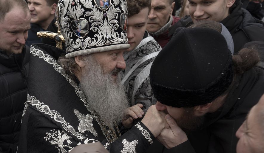 A senior priest of the Ukrainian Orthodox Church blesses parishioners in the Kyiv Pechersk Lavra monastery complex in Kyiv, Ukraine, Wednesday, March 29, 2023. The Russian invasion of Ukraine is reverberating in a struggle for control of a monastery complex. The government says it&#x27;s evicting the Ukrainian Orthodox Church from the complex as of March 29, accusing it of pro-Russia actions and ideology. (AP Photo/Andrew Kravchenko)