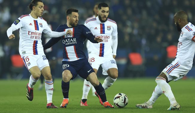 Lyon&#x27;s Maxence Caqueret, left, Alexandre Lacazette, right, and Rayan Cherki, second from right, challenge for the ball with PSG&#x27;s Lionel Messi during the French League One soccer match between Paris Saint-Germain and Lyon at the Parc des Princes stadium in Paris, Sunday, April 2, 2023. (AP Photo/Aurelien Morissard)
