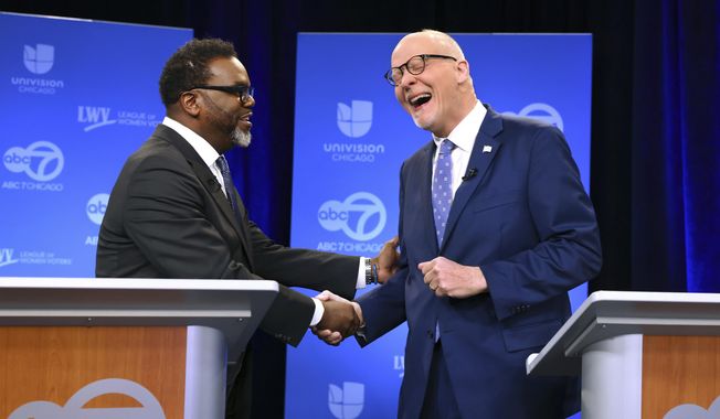 Chicago mayoral candidates Brandon Johnson, left, and Paul Vallas shake hands before the start of a debate at ABC7 studios in downtown Chicago, Thursday, March 16, 2023. (Chris Sweda/Chicago Tribune via AP, Pool)