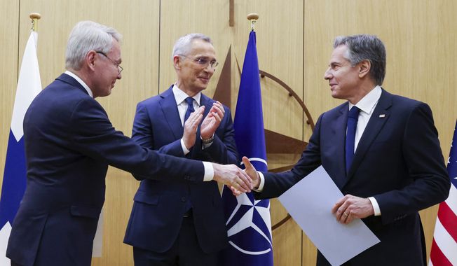Finnish Foreign Minister Pekka Haavisto, left, shakes hands with United States Secretary of State Antony Blinken, right, after handing over his nation&#x27;s accession document during a meeting of NATO foreign ministers at NATO headquarters in Brussels, Tuesday, April 4, 2023. Finland joined the NATO military alliance on Tuesday, dealing a major blow to Russia with a historic realignment of the continent triggered by Moscow&#x27;s invasion of Ukraine. Standing alongside NATO Secretary-General Jens Stoltenberg (center), Mr. Blinken quipped that the alliance can thank Russian President Vladimir Putin for Finland’s decision to join NATO. (Johanna Geron, Pool Photo via AP)