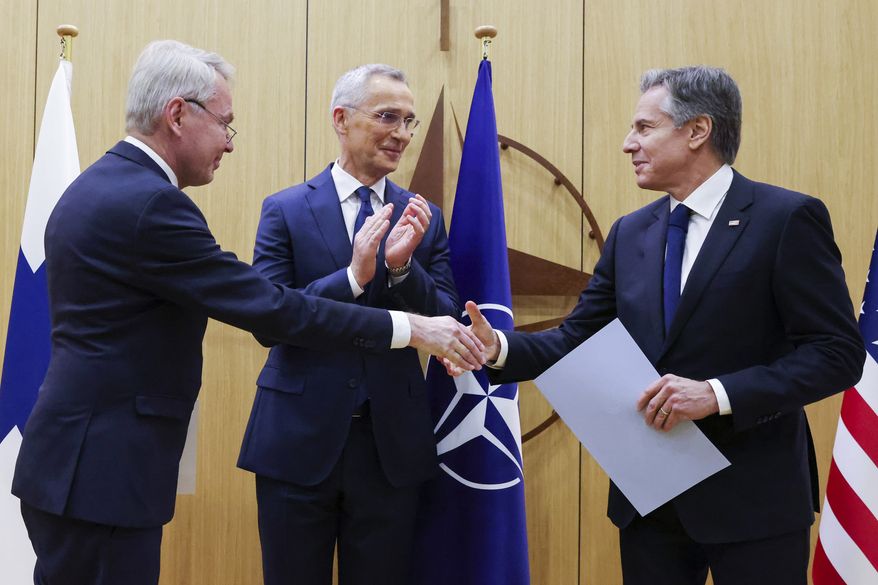 Finnish Foreign Minister Pekka Haavisto, left, shakes hands with United States Secretary of State Antony Blinken, right, after handing over his nation's accession document during a meeting of NATO foreign ministers at NATO headquarters in Brussels, Tuesday, April 4, 2023. Finland joined the NATO military alliance on Tuesday, dealing a major blow to Russia with a historic realignment of the continent triggered by Moscow's invasion of Ukraine. Standing alongside NATO Secretary-General Jens Stoltenberg (center), Mr. Blinken quipped that the alliance can thank Russian President Vladimir Putin for Finland’s decision to join NATO. (Johanna Geron, Pool Photo via AP)
