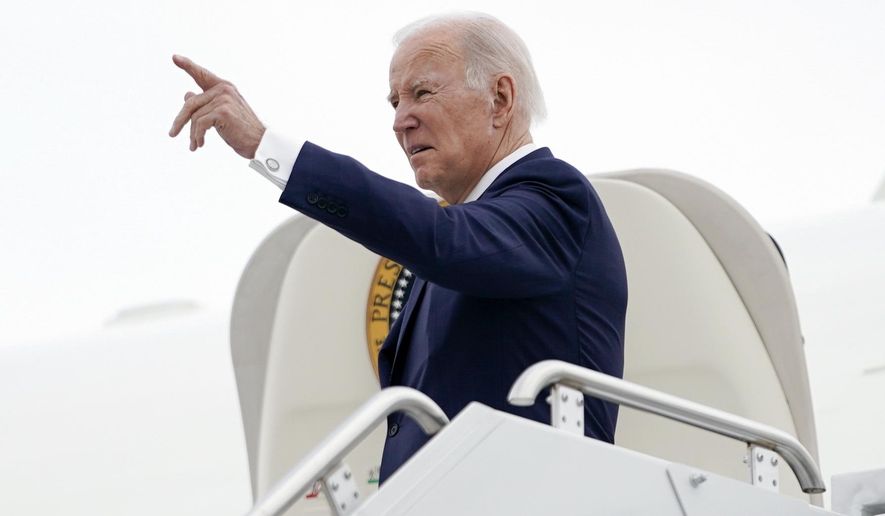 President Joe Biden points as he stands at the top of the steps of Air Force One before boarding at Minneapolis−Saint Paul International Airport, Monday, April 3, 2023, in Minneapolis, en route to Washington. (AP Photo/Carolyn Kaster)