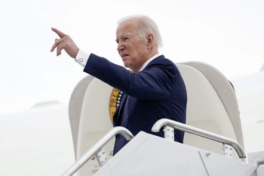 President Joe Biden points as he stands at the top of the steps of Air Force One before boarding at Minneapolis−Saint Paul International Airport, Monday, April 3, 2023, in Minneapolis, en route to Washington. (AP Photo/Carolyn Kaster)