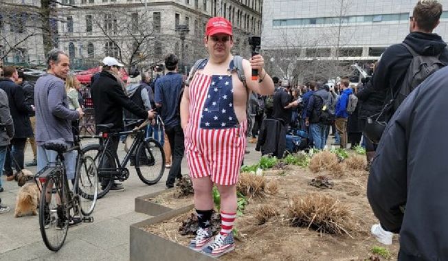 A pro-Trump demonstrator flashes his support for the former president ahead of his arraignment outside the Manhattan courthouse. The area around the criminal court building was a hive of activity ahead of former President Donald Trump&#x27;s appearance. (Photo: Tom Howell Jr. / The Washington Times)