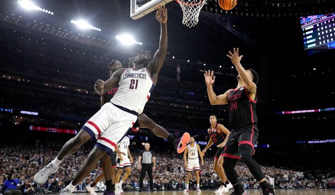 Connecticut forward Adama Sanogo (21) and San Diego State guard Matt Bradley vie for a rebound during the first half of the men&#x27;s national championship college basketball game in the NCAA Tournament on Monday, April 3, 2023, in Houston. (AP Photo/Brynn Anderson)