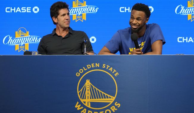 Golden State Warriors forward Andrew Wiggins, right, and general manager Bob Myers take part in a news conference before an NBA basketball game between the Warriors and the Oklahoma City Thunder in San Francisco, Tuesday, April 4, 2023. (AP Photo/Jeff Chiu)