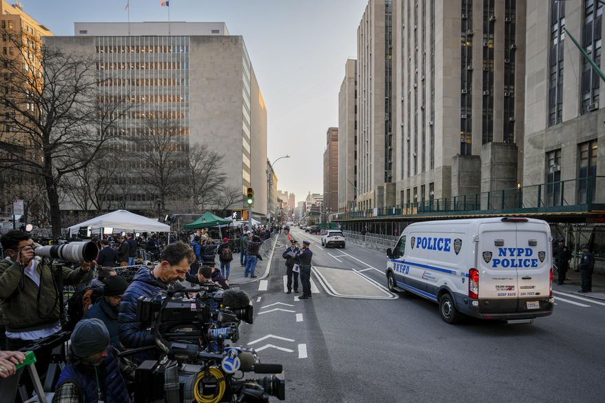 Journalists gather across the street from Manhattan Criminal Court, Tuesday, April 4, 2023, in New York. Former President Donald Trump will surrender in Manhattan on Tuesday to face criminal charges stemming from 2016 hush money payments. (AP Photo/John Minchillo)