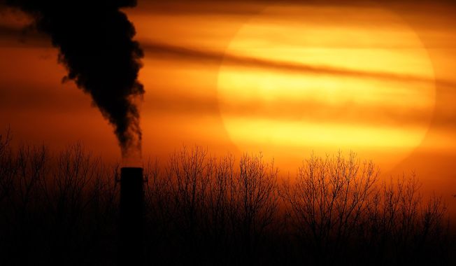 Emissions from a coal-fired power plant are silhouetted against the setting sun in Kansas City, Mo., Feb. 1, 2021. The Environmental Protection Agency is tightening rules that limit emissions of mercury and other harmful pollutants from coal-fired power plants, updating standards imposed more than a decade ago. (AP Photo/Charlie Riedel, File)