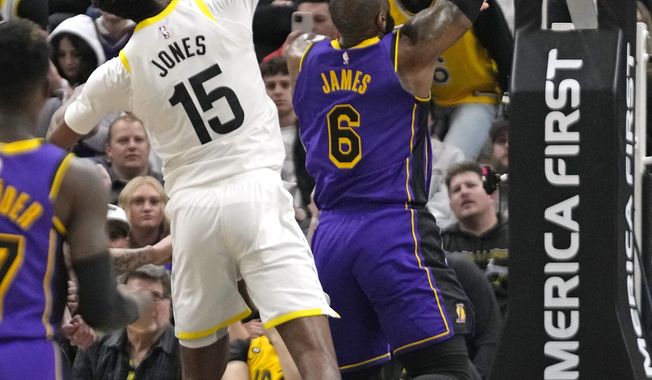 Los Angeles Lakers forward LeBron James (6) scores as Utah Jazz center Damian Jones (15) defends during overtime in an NBA basketball game Tuesday, April 4, 2023, in Salt Lake City. (AP Photo/Rick Bowmer)