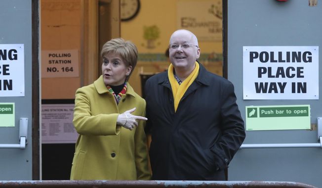 Scottish First Minister Nicola Sturgeon poses for the media with her husband, Peter Murrell, outside a polling station in Glasgow, Scotland, on Dec. 12, 2019. British media are reporting that the husband of former Scottish National Party leader Nicola Sturgeon has been arrested in a party finance probe on Wednesday, April 5, 2023. (AP Photo/Scott Heppell, File)
