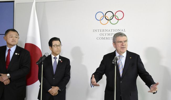 Japanese Olympic Committee President Yasuhiro Yamashita, from left, and Sapporo Mayor Katsuhiro Akimoto listen to International Olympic Committee President Thomas Bach, right, speak during a news conference in Lausanne, Switzerland, on Jan. 11, 2020. Sapporo&#x27;s bid for the 2030 Winter Olympics has been slowed, but not stopped, by fallout from the still-developing corruption scandal around the 2020 Tokyo Games. (Masashi Inoue/Kyodo News via AP)