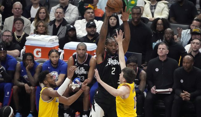 Los Angeles Clippers forward Kawhi Leonard (2) looks to pass the ball as Los Angeles Lakers guard Austin Reaves, right, and forward Troy Brown Jr. defend during the first half of an NBA basketball game Wednesday, April 5, 2023, in Los Angeles. (AP Photo/Marcio Jose Sanchez)