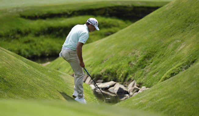 Sergio Garcia, of Spain, fishes his ball out of the creek on the 13th hole during the first round of the Masters golf tournament at Augusta National Golf Club on Thursday, April 6, 2023, in Augusta, Ga. (AP Photo/David J. Phillip)