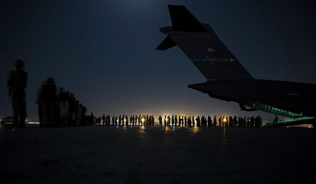 In this Aug. 21, 2021, file image provided by the U.S. Air Force, U.S. Air Force aircrew, assigned to the 816th Expeditionary Airlift Squadron, prepare to load qualified evacuees aboard a U.S. Air Force C-17 Globemaster III aircraft in support of the Afghanistan evacuation at Hamid Karzai International Airport, Kabul, Afghanistan. (Senior Airman Taylor Crul/U.S. Air Force via AP, File)