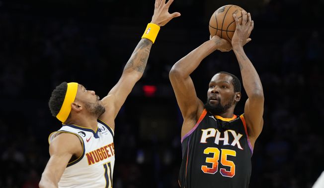Phoenix Suns forward Kevin Durant (35) shoots over Denver Nuggets forward Bruce Brown during the first half of an NBA basketball game Thursday, April 6, 2023, in Phoenix. (AP Photo/Rick Scuteri)