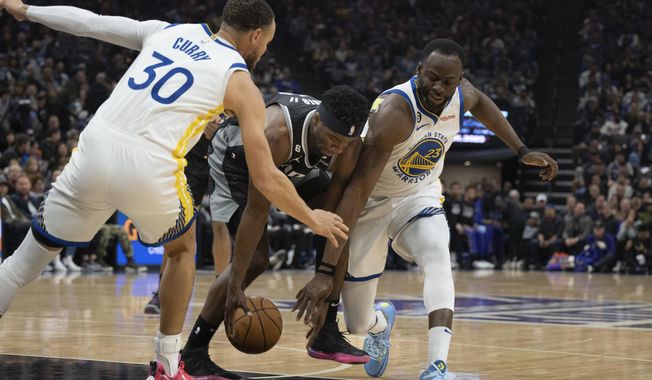 Golden State Warriors guard Stephen Curry (30) and forward Draymond Green (23) strip the ball away from Sacramento Kings guard Terence Davis, center, in the first quarter in an NBA basketball game in Sacramento, Calif., Friday, April 7, 2023. (AP Photo/José Luis Villegas)