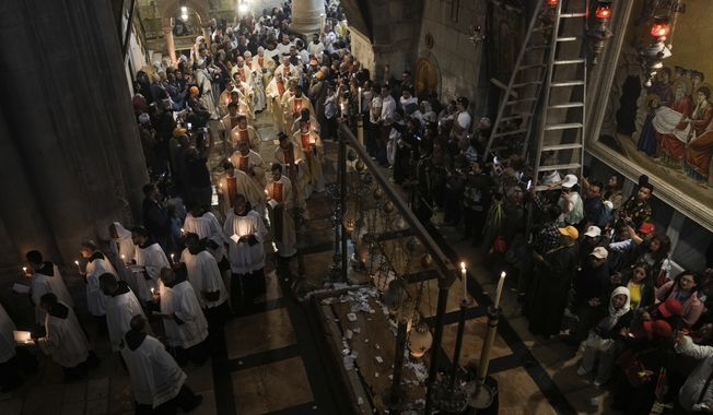 Priests participate in the Easter Sunday Mass led by the Latin Patriarch of Jerusalem Pierbattista Pizzaballa, at the Church of the Holy Sepulcher, where many Christians believe Jesus was crucified, buried and rose from the dead, in the Old City of Jerusalem, Sunday, April 9, 2023. (AP Photo/Mahmoud Illean)