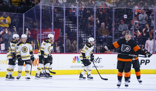 Boston Bruins&#x27; David Pastrnak, second from left, celebrates his second goal with teammates during the second period of an NHL hockey game against the Philadelphia Flyers, Sunday, April 9, 2023, in Philadelphia. (AP Photo/Chris Szagola)