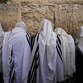 Covered in prayer shawls, Jewish men pray during the holiday of Passover, in front of the Western Wall, the holiest site where Jews can pray, in Jerusalem&#x27;s Old City, Sunday, April 9, 2023. (AP Photo/Ohad Zwigenberg)
