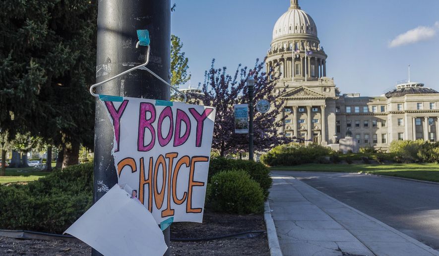A sign reading &quot;My body, my choice,&quot; is taped to a hanger taped to a streetlight in front of the Idaho state Capitol Building in Boise, Idaho, May 3, 2022. Abortion is banned in Idaho at all stages of pregnancy, but the governor on Wednesday, April 5, 2023, signed another law making it illegal to provide help within the state’s boundaries to minors seeking abortion without parental consent. (Sarah A. Miller/Idaho Statesman via AP) **FILE**
