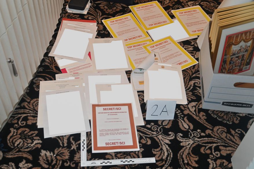 This image contained in a court filing by the Department of Justice on Aug. 30, 2022, and partially redacted by the source, shows a photo of documents seized during the Aug. 8 FBI search of former President Donald Trump's Mar-a-Lago estate. The Biden administration has begun sharing with a bipartisan group of lawmakers known as the Gang of Eight classified documents found in the possession of Trump, President Joe Biden and former Vice President Mike Pence. (Department of Justice via AP, File)
