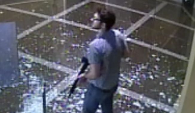 This surveillance video provided by the Louisville Metro Police Department shows bank employee Connor Sturgeon, 25, carrying an AR-15 assault-style rifle after opening fire at Old National Bank, in Louisville, Ky., Monday, April 10, 2023. (Courtesy of Louisville Metro Police Department via AP)