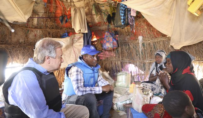 UN Sec General, Antonio Guterres, left talks to Somali family through a translator, middle, in a refugee camp in Mogadishu Tuesday April 11, 2023. U.N Secretary-General Antonio Guterres has appealed for “massive international support” for Somalia as he visited the East African country that is facing the worst drought in decades. (AP Photo)