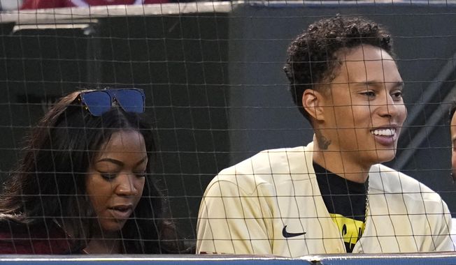 WNBA Phoenix Mercury basketball player Brittney Griner, right, sits next to her wife, Cherelle Griner, during the first inning of a baseball game between the Arizona Diamondbacks and the Milwaukee Brewers Tuesday, April 11, 2023, in Phoenix. (AP Photo/Ross D. Franklin)