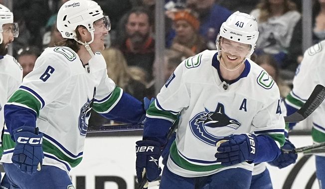 Vancouver Canucks center Elias Pettersson, right, celebrates his goal with right wing Brock Boeser during the first period of an NHL hockey game against the Anaheim Ducks Tuesday, April 11, 2023, in Anaheim, Calif. (AP Photo/Mark J. Terrill)