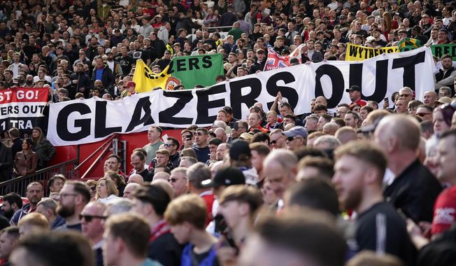 A banner writing &#x27; Glazers out&#x27; is displayed by spectators during the English Premier League soccer match between Manchester United and Everton, at the Old Trafford stadium in Manchester, England, Saturday, April 8, 2023. (AP Photo/Dave Thompson)