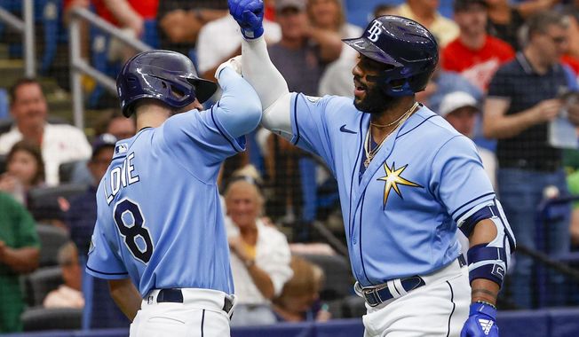 Tampa Bay Rays&#x27; Brandon Lowe (8) and Yandy Diaz (2) celebrate a solo home run in the first inning of a baseball game against the Boston Red Sox at Tropicana Field in St. Petersburg, Fla., Thursday, April 13, 2023. (Ivy Ceballo/Tampa Bay Times via AP)