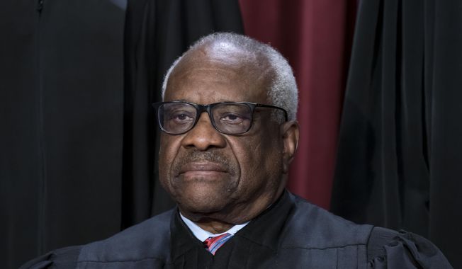 Associate Justice Clarence Thomas joins other members of the Supreme Court as they pose for a new group portrait, at the Supreme Court building in Washington, Oct. 7, 2022. Conservative megadonor Harlan Crow purchased three properties belonging to Thomas and his family, in a transaction worth more than $100,000 that Thomas never reported, according to the nonprofit investigative journalism organization ProPublica on Thursday, April 13, 2023. (AP Photo/J. Scott Applewhite, File)