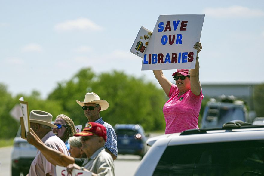 Llano resident Emily Decker protests outside a Llano County Commissioner's Court meeting at the Llano County Law Enforcement Center on Thursday, April 13, 2023 in Llano, Texas. Leaders in a rural Texas county held a special meeting Thursday but drew back from considering shutting their public library system rather than follow a federal judge's order to return books to the shelves on themes ranging from teen sexuality to bigotry. (Aaron E. Martinez/Austin American-Statesman via AP) **FILE**