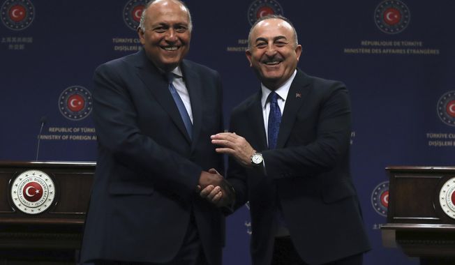 Turkish Foreign Minister Mevlut Cavusoglu, right, and his Egyptian counterpart Sameh Shoukry shake hands after a joint news conference, in Ankara, Turkey, Thursday, April 13, 2023. Shoukry is in Turkey as the two countries attempt to improve relations. (AP Photo/Burhan Ozbilici)