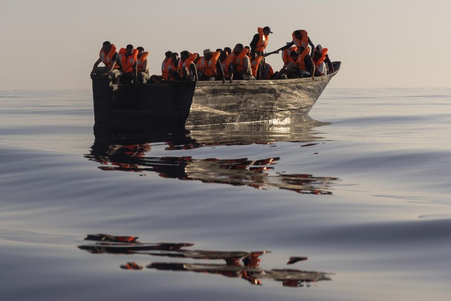 Migrants with life jackets provided by volunteers of the Ocean Viking, a migrant search and rescue ship run by NGOs SOS Mediterranee and the International Federation of Red Cross (IFCR), sail in a wooden boat as they are being rescued some 26 nautical milessouth of the Italian Lampedusa island in the Mediterranean sea,on Aug. 27,2022. The U.N. human rights chief is appealing to governments to do more to help migrants and asylum-seekers after a “steep increase” in the numbers making risky attempts to cross the central Mediterranean to Europe. (AP Photo/Jeremias Gonzalez, File)