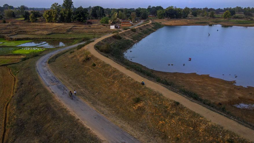 A villager sits on the shore of a lake in Haripur village in Ambikapur district, Chhattisgarh state, India, Monday, March 20, 2023. Health inequities aren't unique to India, but the sheer scale of its population means that fragile systems are severely stretched. For the poor, this can have devastating consequences. (AP Photo/Rafiq Maqbool) ** FILE **
