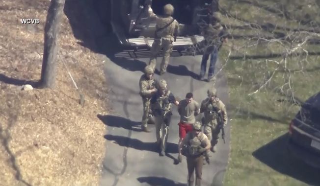 This image made from video provided by WCVB-TV, shows Jack Teixeira, in T-shirt and shorts, being taken into custody by armed tactical agents on Thursday, April 13, 2023, in Dighton, Mass. Teixeira, who is accused in the leak of highly classified military documents, appeared in court Friday as prosecutors unsealed charges and revealed how billing records and interviews with social media comrades helped pinpoint the suspect. (WCVB-TV via AP, File)