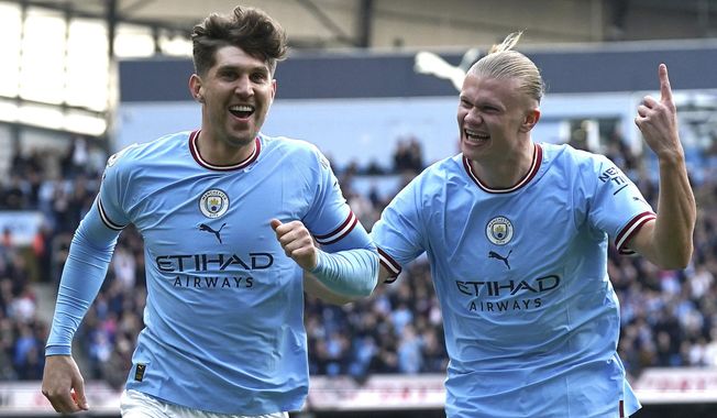 Manchester City&#x27;s John Stones, left, celebrates with teammate Erling Haaland after scoring his side&#x27;s opening goal during the English Premier League soccer match between Manchester City and Leicester City at Etihad Stadium in Manchester, England, Saturday, April 15, 2023. (Nick Potts/PA via AP)
