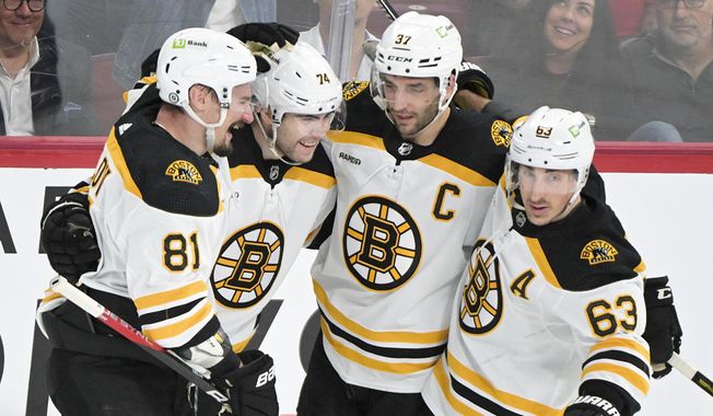 Boston Bruins&#x27; Jake DeBrusk (74) celebrates with teammates after scoring against the Montreal Canadiens during the first period of an NHL hockey game Thursday, April 13, 2023, in Montreal. (Graham Hughes/The Canadian Press via AP)